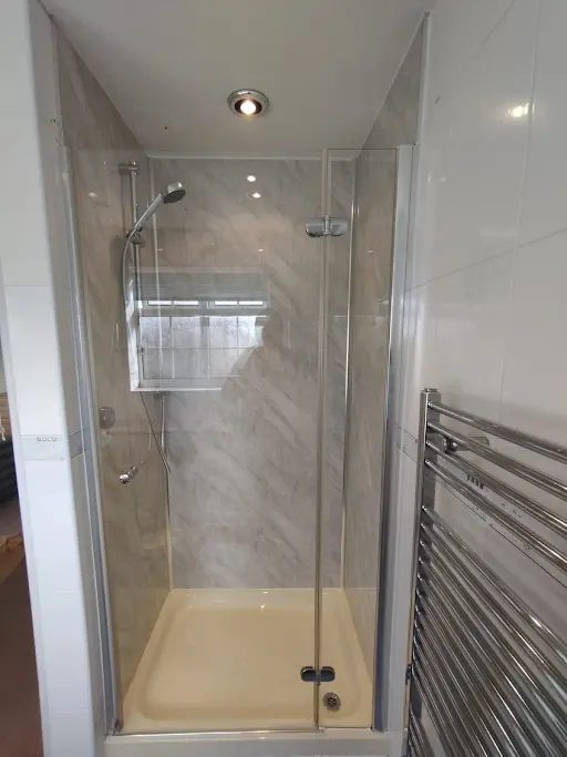 Completed shower installation with marble wall panels